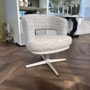 Light gray textured swivel chair with a square open back, displayed in a furniture showroom on a metal four‑leg base.