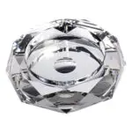 Top view of a faceted crystal candle holder with a circular cavity for a tealight, reflecting light.