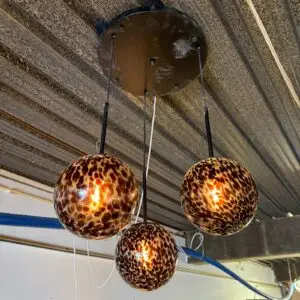 Leopard-print glass pendant lights hanging from the ceiling, glowing warmly.