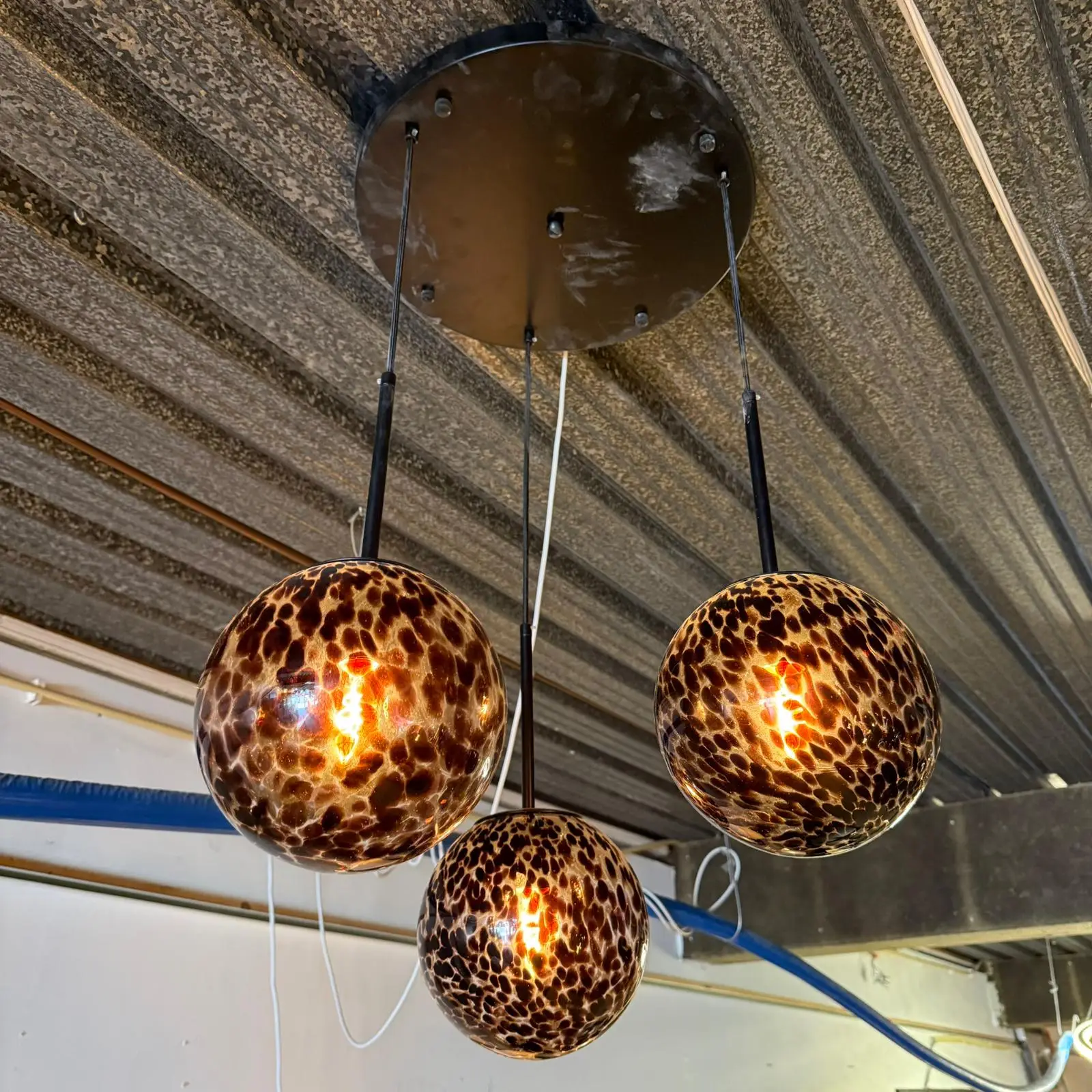 Leopard-print glass pendant lights hanging from the ceiling, glowing warmly.
