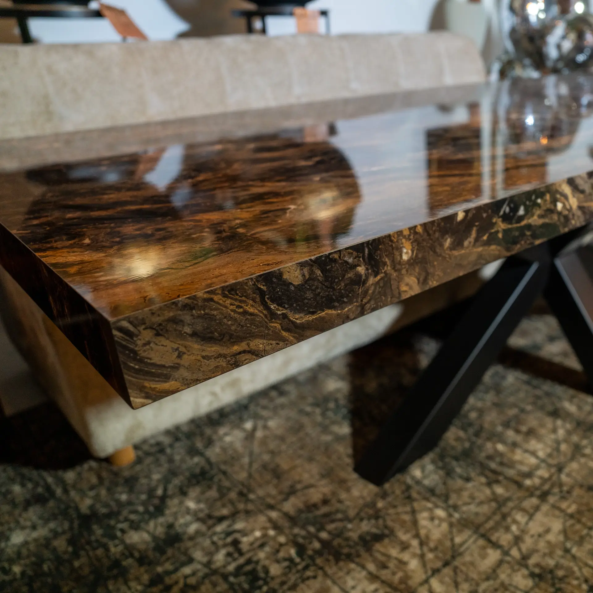 Blurry close-up of a polished dark brown granite counter with light and gold speckles and a glossy finish.