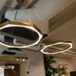 Interior shot of circular halo pendant lights hanging from a ceiling in a cafe or restaurant.