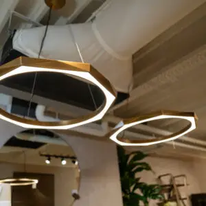 Interior shot of circular halo pendant lights hanging from a ceiling in a cafe or restaurant.