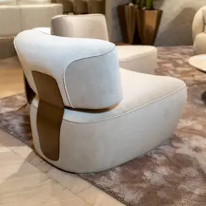 Close-up of a pale blue curved lounge chair in a modern seating area, with a marbled floor and carpet in the background.