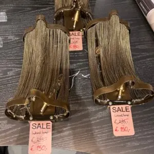 Brown metal-framed chandelier with gold beaded fringe on display; sale tag shows €150.
