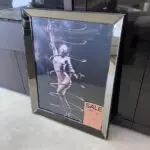 Framed black-and-white poster of a dancer wrapped in spiraling hoops, reaching upward.
